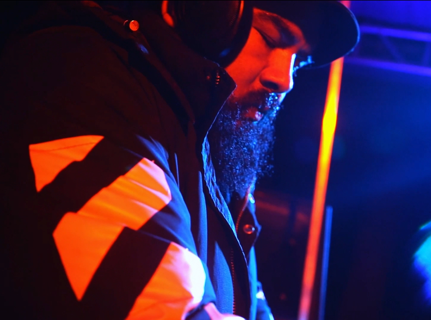 SERGIK on rooftop at night with city lights